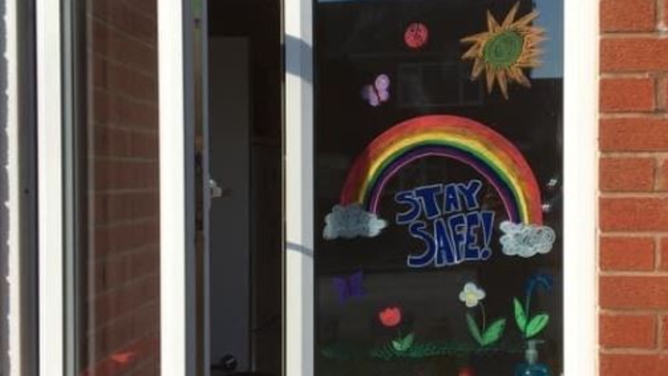 Stay safe decorative rainbows drawn on a window