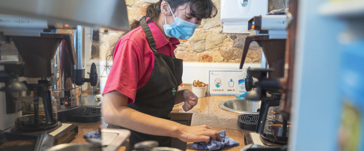 Student wiping work surface in Barrow of Treats