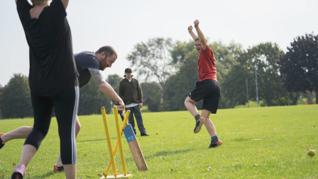 Student cheering after throwing a cricket ball and the staff member missing the ball