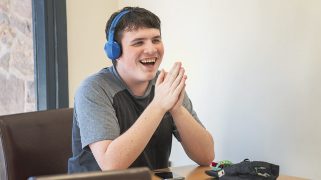 Student laughing with hands clapping