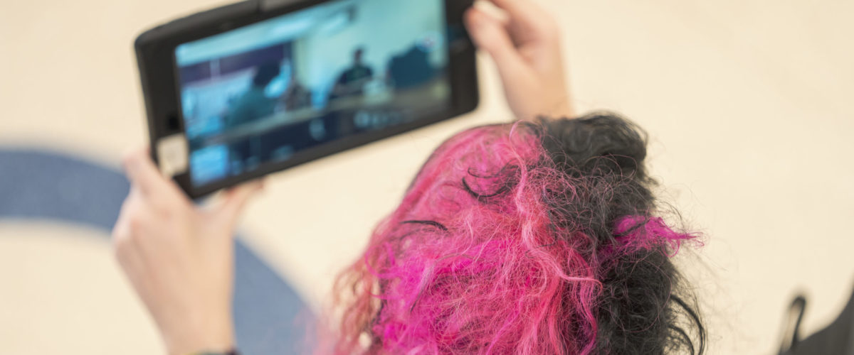 Aerial shot of a person holding an ipad taking a photo of students