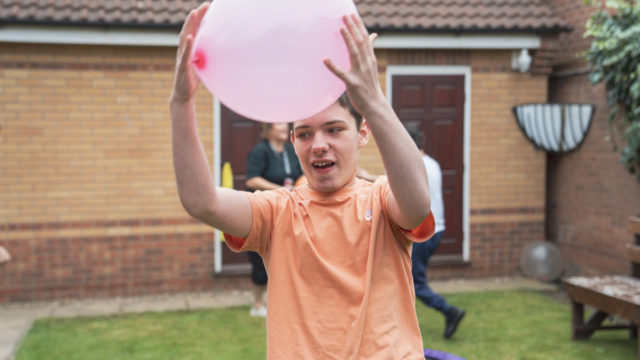 Student catching a balloon in the garden