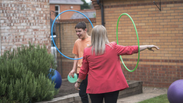 Student and staff playing with hula-hoops