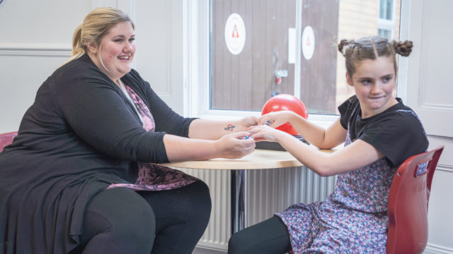 Learning Support Assistant performing massage on student hands