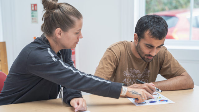 Learning Support Assistant helping a student with their worksheet