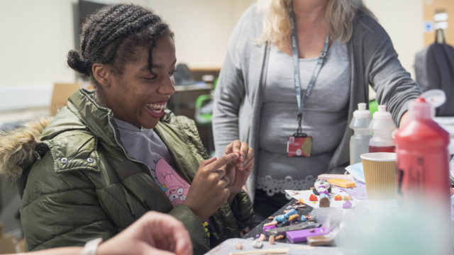 Student creating doll out of modelling clay