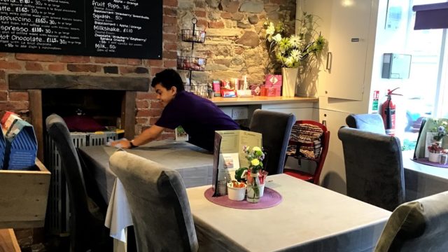 Student cleaning tables in Barrow of Treats