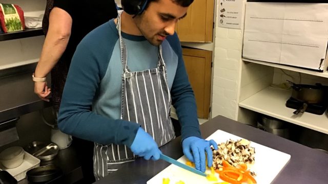 Student chopping food in the kitchen