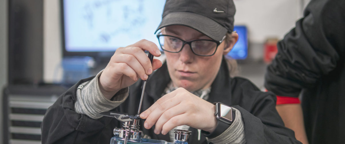 Student using tools on motor vehicle component