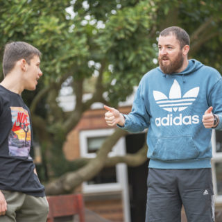 Student smiling at tutor who has their thumbs up