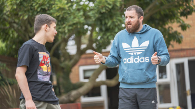 Student smiling at tutor who has their thumbs up