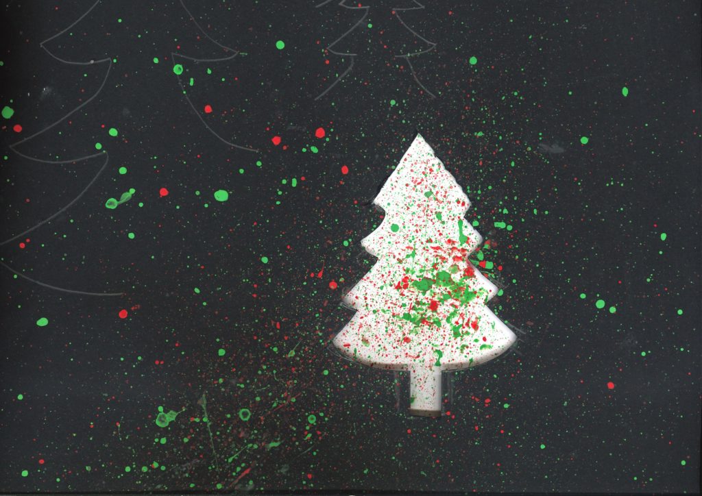 Splatter painting on a black background with a white tree in the middle