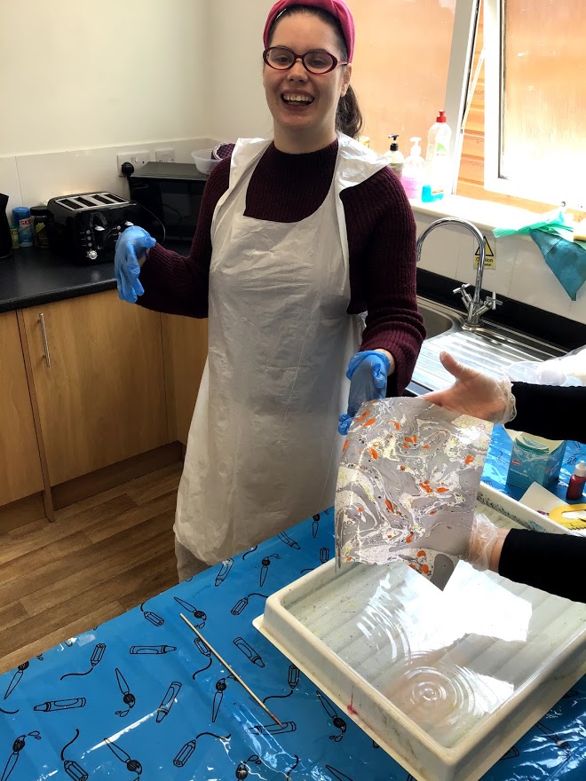 Student pulling out a marbled piece of paper from a water tray