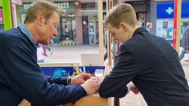 Student and Timpson staff member looking at watch mechanism