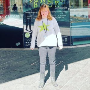 girl stood in front of theatre poster