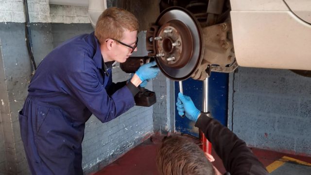 Student working on car wheel