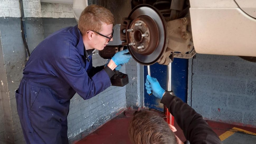 Student working on car wheel