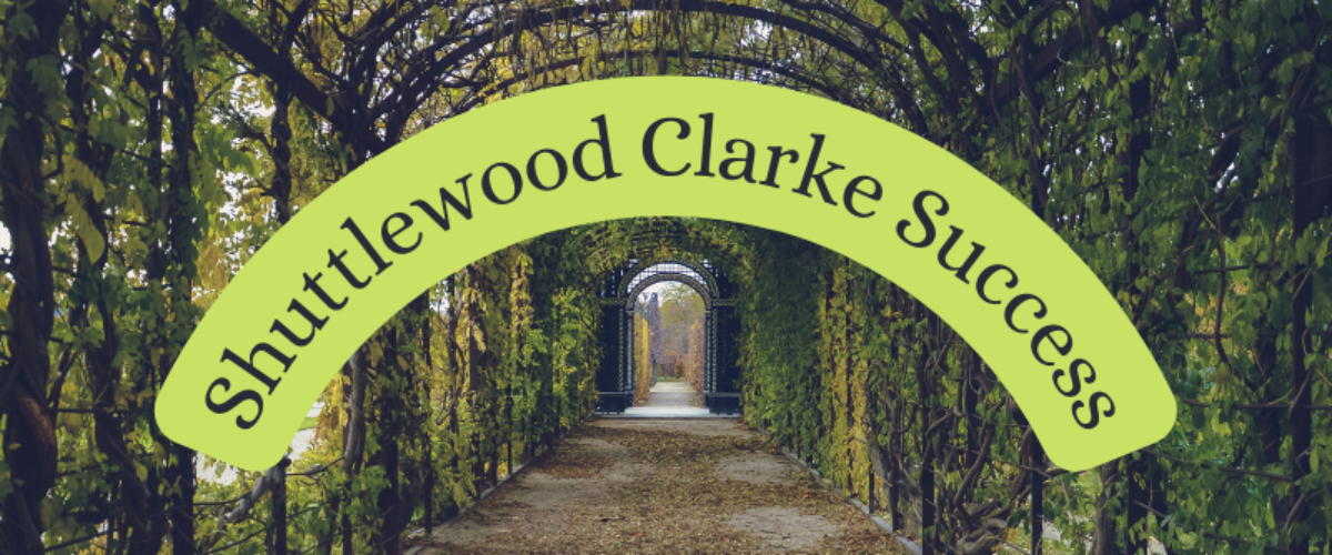 Garden archway with curved text title. Text reads Shuttlewood Clarke Success