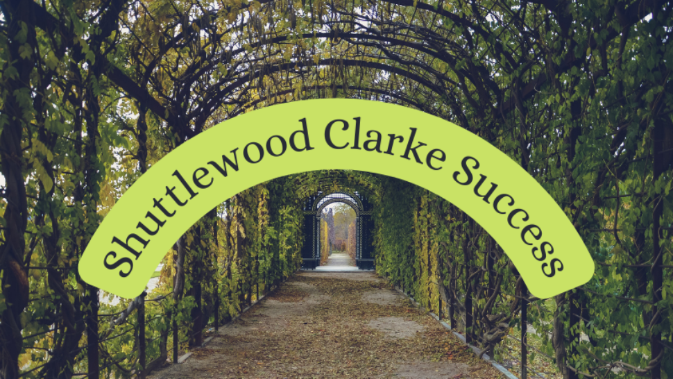 Garden archway with curved text title. Text reads Shuttlewood Clarke Success