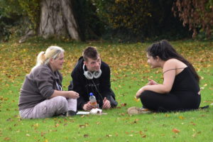 Students and staff chatting on the grass