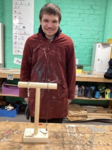 Woodwork student showing their jewellery hanger