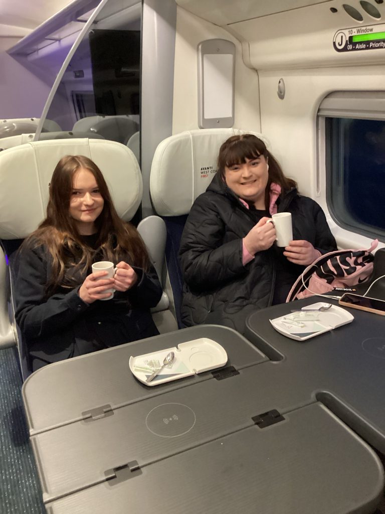 Skye and Livvy drinking their morning tea on the train on the way to the final.