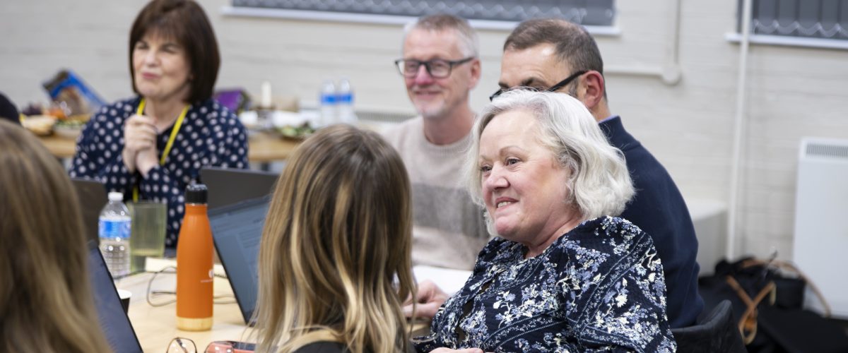 A group of trustees engage in conversation during a meeting.