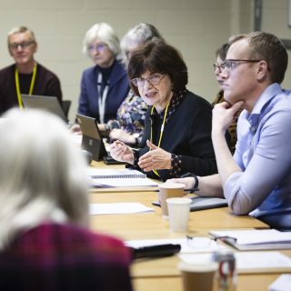 A group of trustees engage in conversation during a meeting.