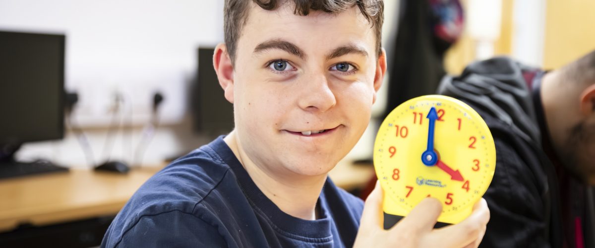 Student holding up a clock