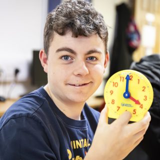 Student holding up a clock