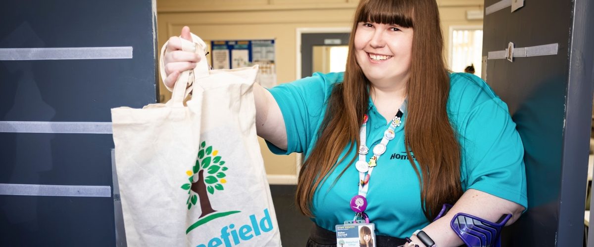 Staff member holding a goodie bag