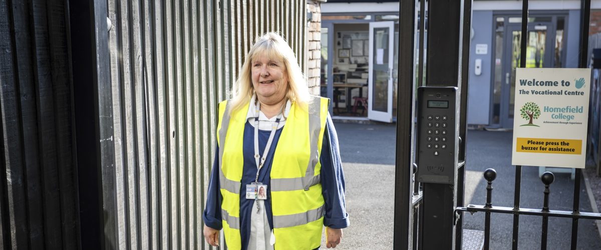 Staff member smiling in a high vis jacket