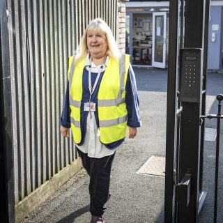 Staff member smiling in a high vis jacket