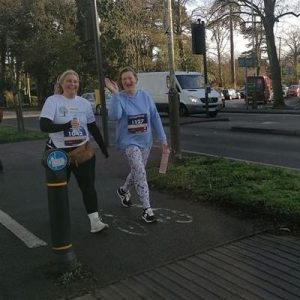 A photo of Vikki and Liz walking the race and smiling at the camera.
