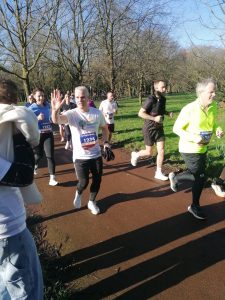 A picture of Vice-Principal Chris high-fiving someone on our cheer team as he runs.