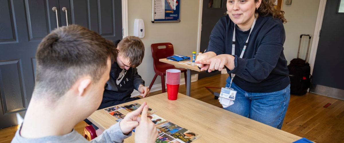 a speech and language therapist signing to a student in a classroom