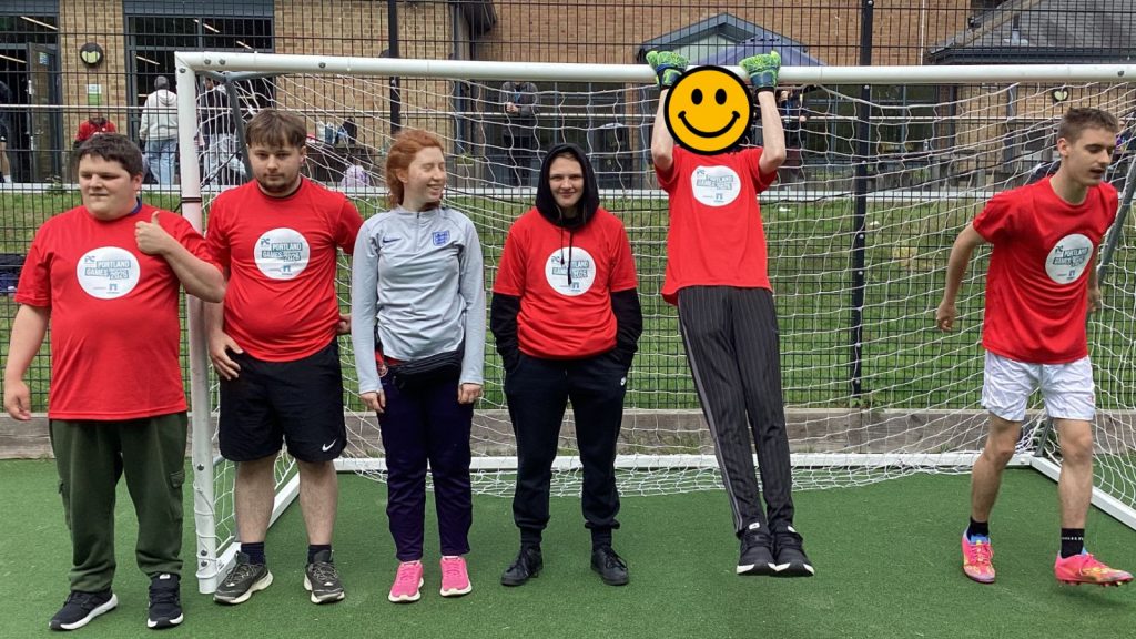 a group photo of the students in front of the football net