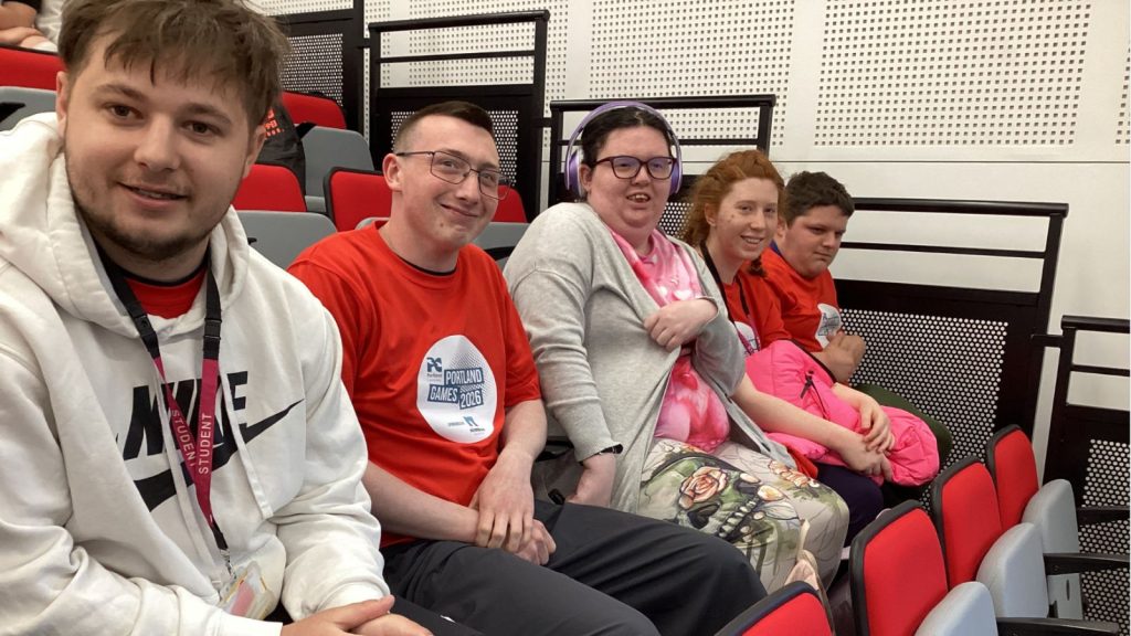 the participating students smiling at the camera from the stadium seats
