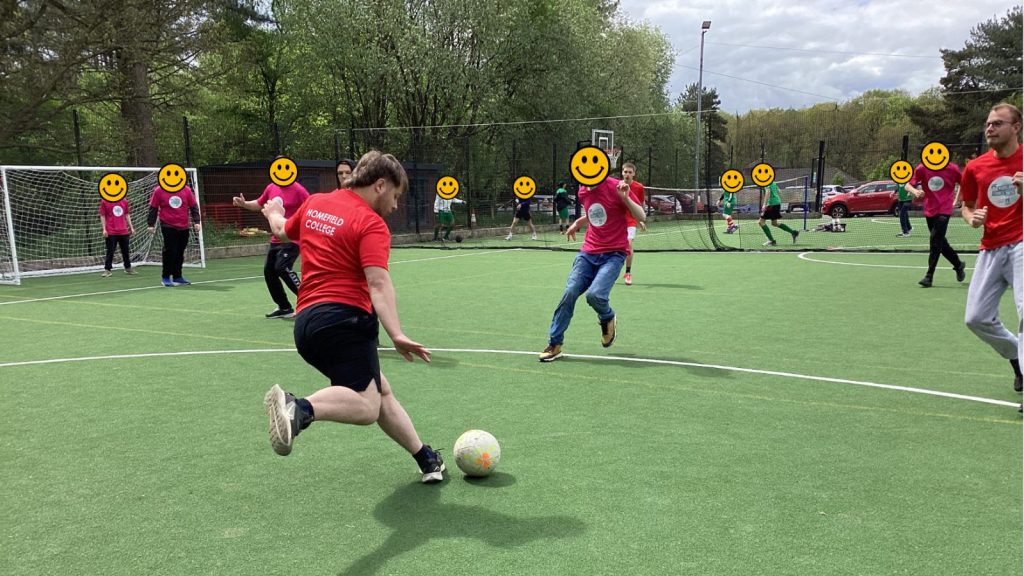 our students and the rival team laying football on the field