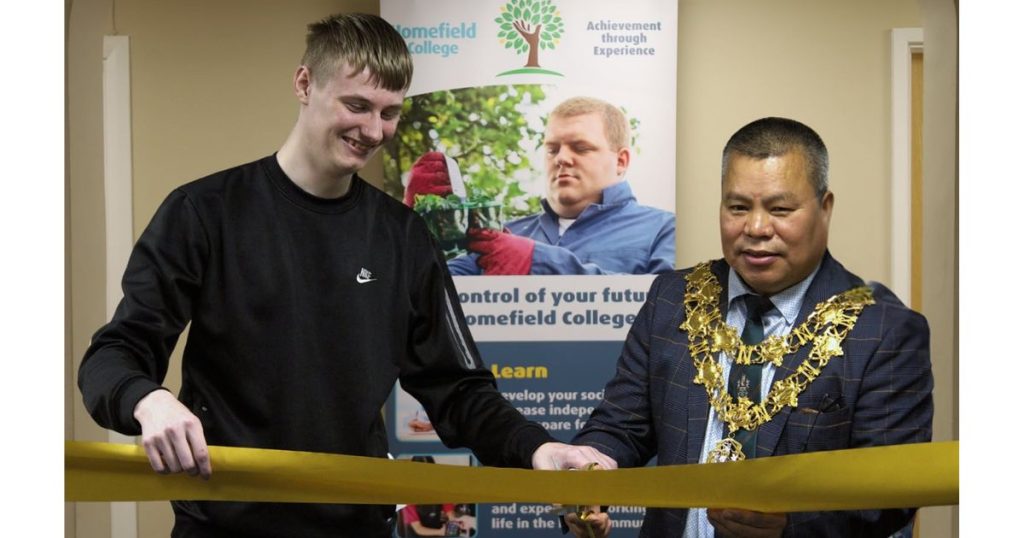 a photo of a Student Union member and The Worshipful The Mayor of Nuneaton and Bedworth cutting the ribbon to officiate the opening of the Parkside college building
