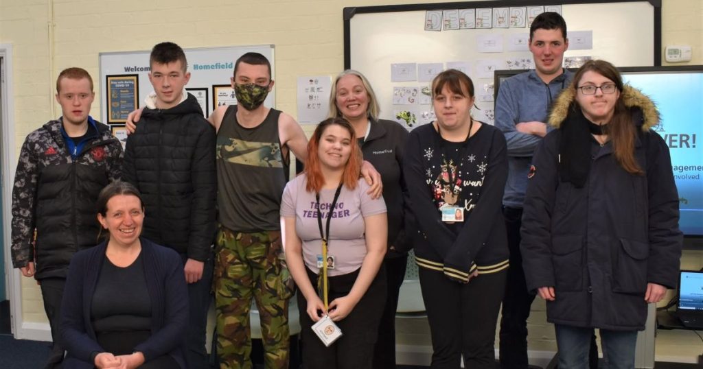 a photo of the previous year's student union members alongside some staff members in a classroom