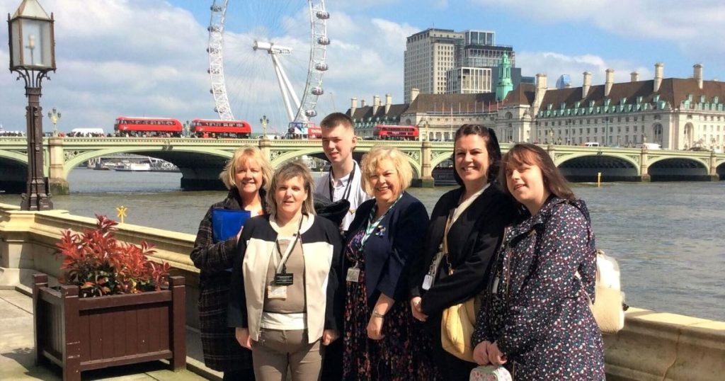 a photo of the previous year's student union members alongside some staff members in front of the London Bridge
