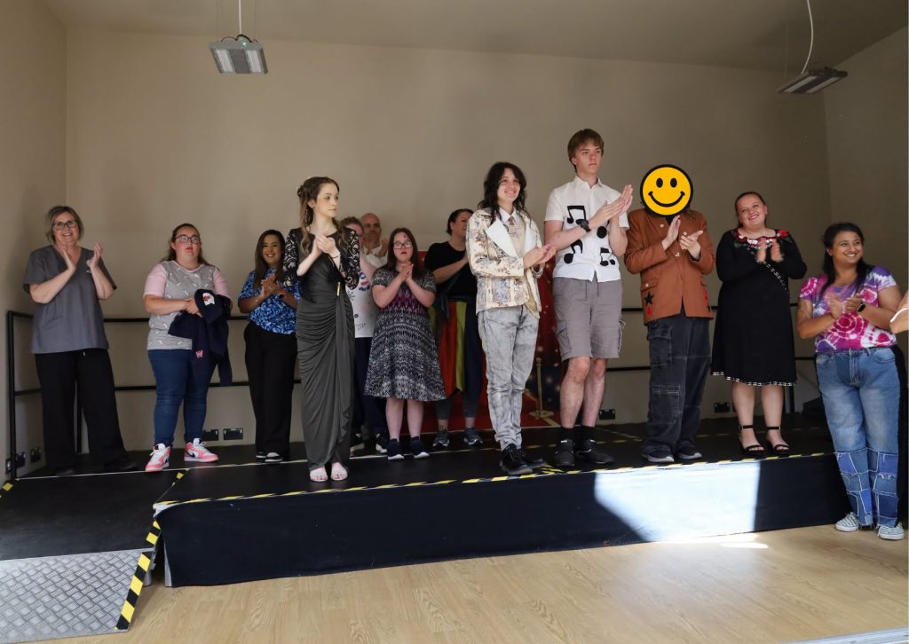 group of students on stage clapping in their outfits