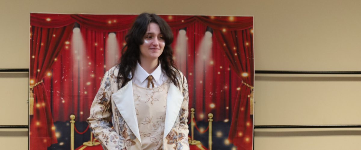 students wearing jacket in front of backdrop
