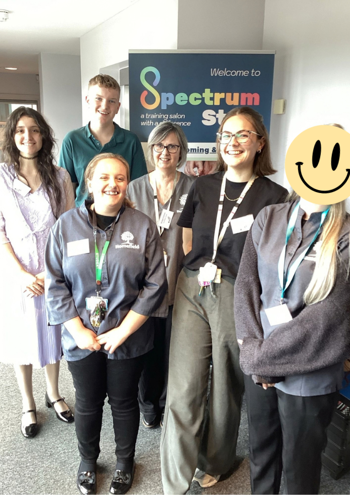 Group of students and staff in front of Spectrum Style banner